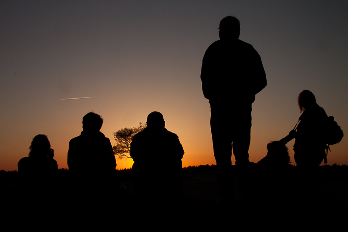 Foto van silhouetten van mensen die genieten van een zonsondergang
